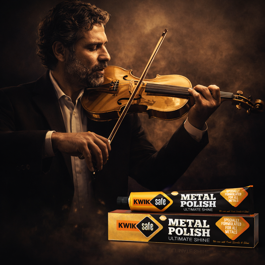 A man in a dark suit holds a violin and bow against a smoky, dramatic brown background. In the lower right, two tubes and a box of Kwik Safe Metal Polish are shown, with the brand name and product text clearly visible.